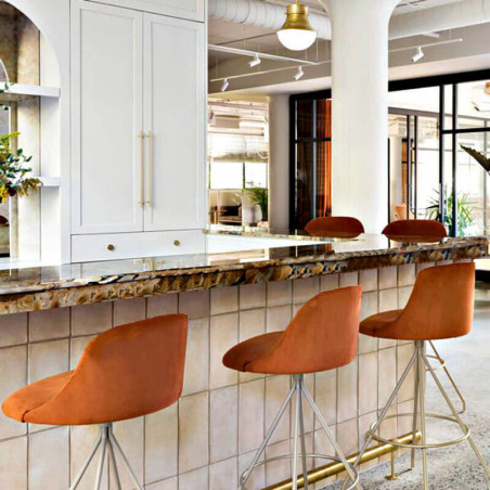 Design swivel bar stool Aleta by Viccarbe in an orange hue at a bar counter| Aiure