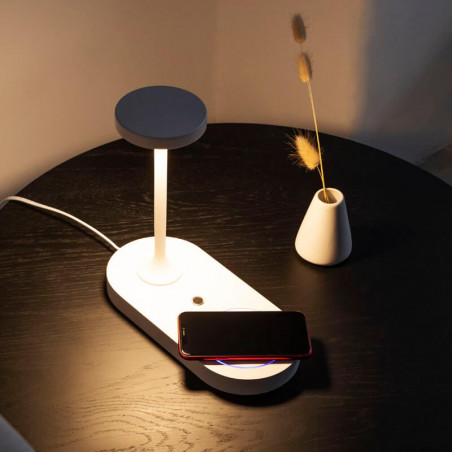 White lamp Ceres charging a phone on a coffee table by Mantra | Aiure