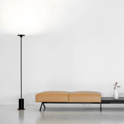 Black floor lamp Up by Arkoslight besides a couch| Aiure