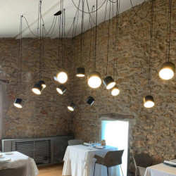 Black Paco ceiling lamp by Ole by FM illuminated over tables in a restaurant | Aiure