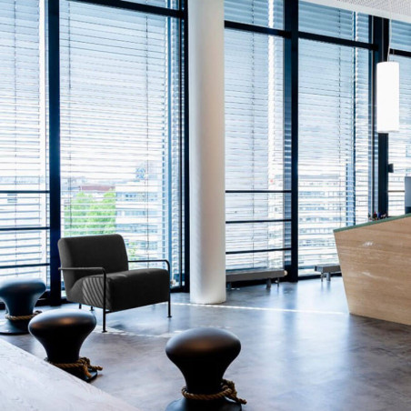 Butaca exterior de diseño Colubi de Viccarbe color negro con reposabrazos de madera en una oficina| Aiure