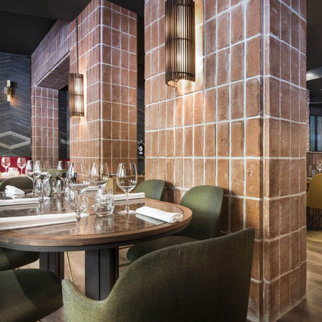 Butaca de diseño Aleta con reposabrazos de Viccarbe en un restaurante| Aiure