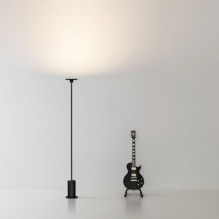 Lámpara de pie negra Up de Arkoslight en interior con una guitarra | Aiure